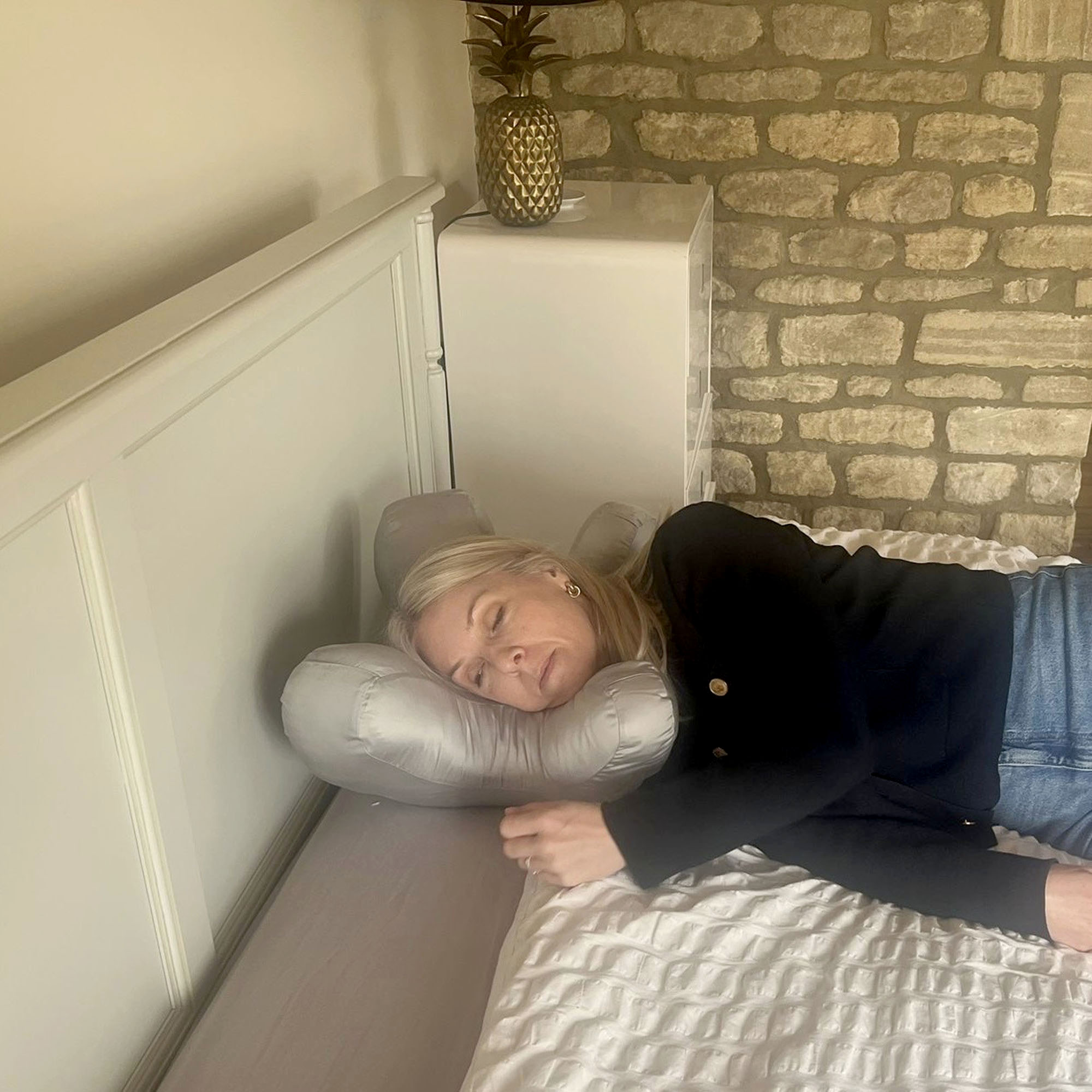 A woman with blonde hair lying on the Dunelm Hotel Touch of Bamboo Anti-Wrinkle Pillow
