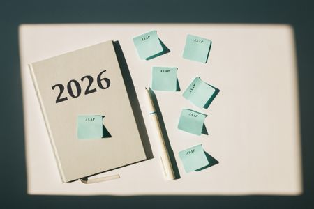 notebook with "2026" on it and a pen and little sticky notes that say "ASAP" 
