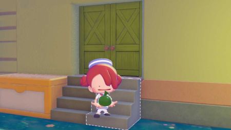 Ditto holds a green Pokopia paint balloon and stands in front of a painted green house.