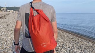 Man wearing Osprey Wildwater Dry Bag on beach