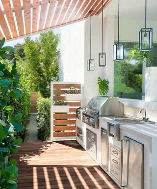 A decked outdoor bbq area with food prep station and deck cover