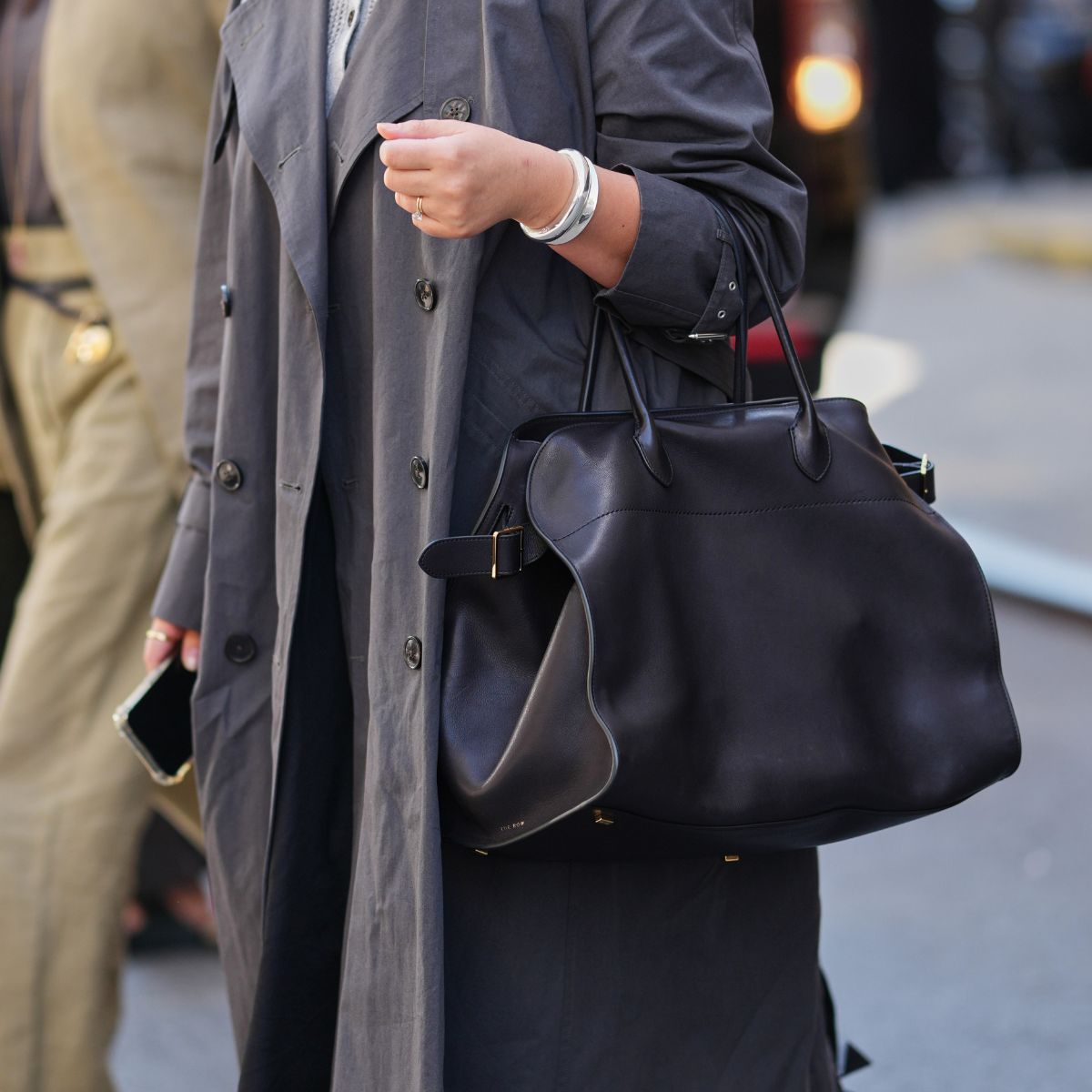 street style shot of woman holding black tote bag