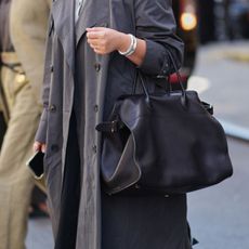 street style shot of woman holding black tote bag
