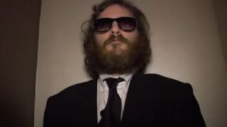 Joaquin Phoenix with sunglasses and a beard, wearing a suit in I'm Still Here