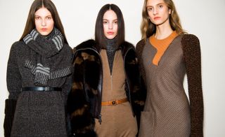 Models wear thick outerwear, with block colours and patterns. One model wears a grey cashmere scarf