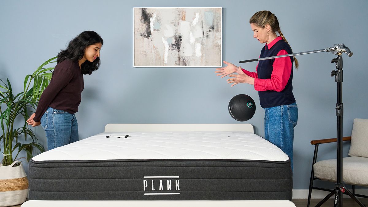 Testers Becky George (left) and Nicola Appleton (right) test the motion isolation of the Plank Firm Luxe mattress. Nicola Appleton is dropping a 5kg slam ball on the mattress while Becky George uses an accelerometer to measure the force and decay rate.