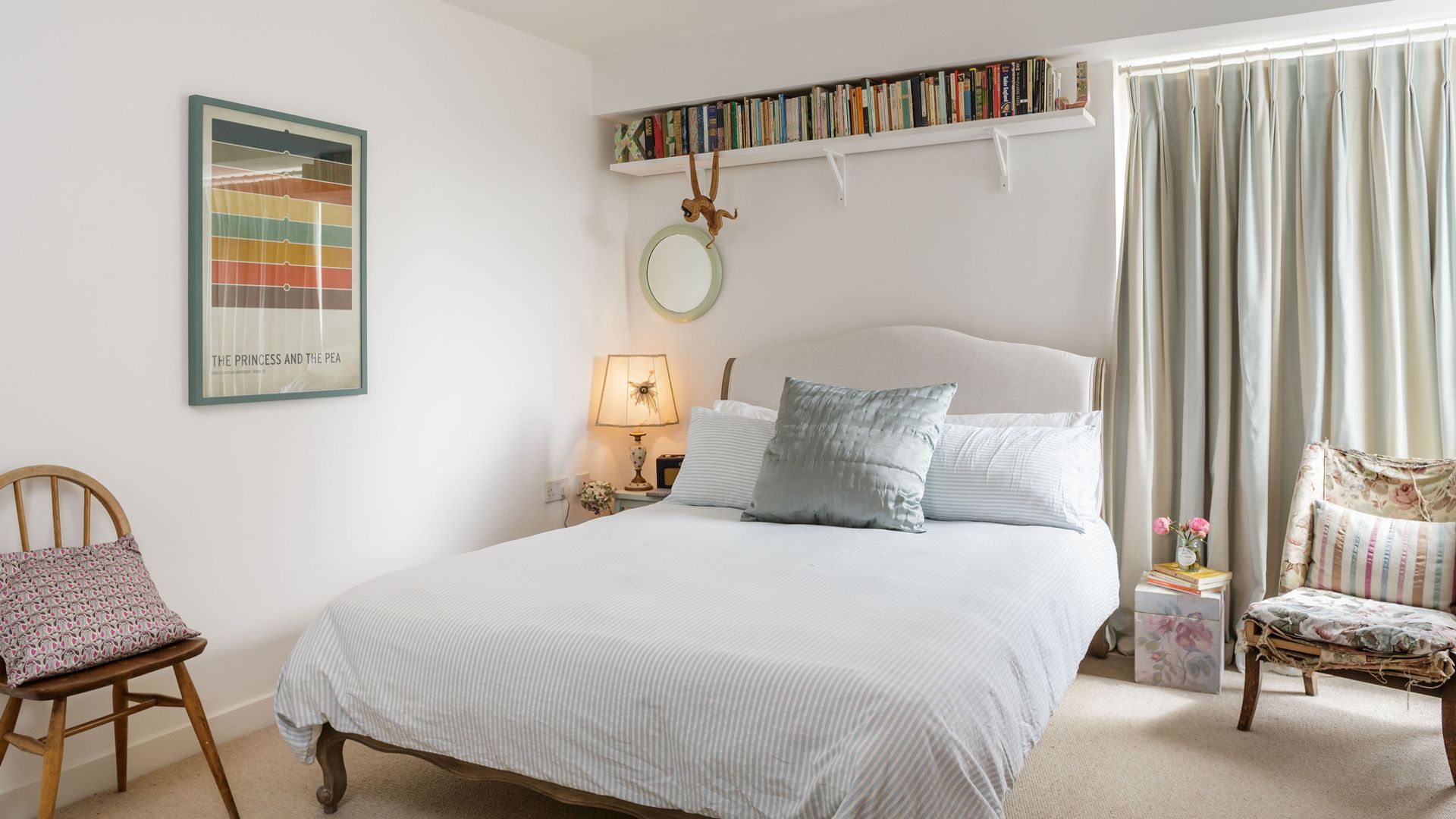 white bedroom with book shelves above the bed to show how to organize a small bedroom more efficiently