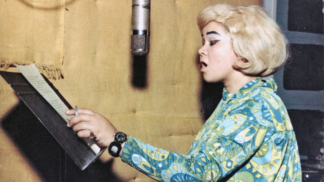 Etta James singing in the studio, holding a cigarette