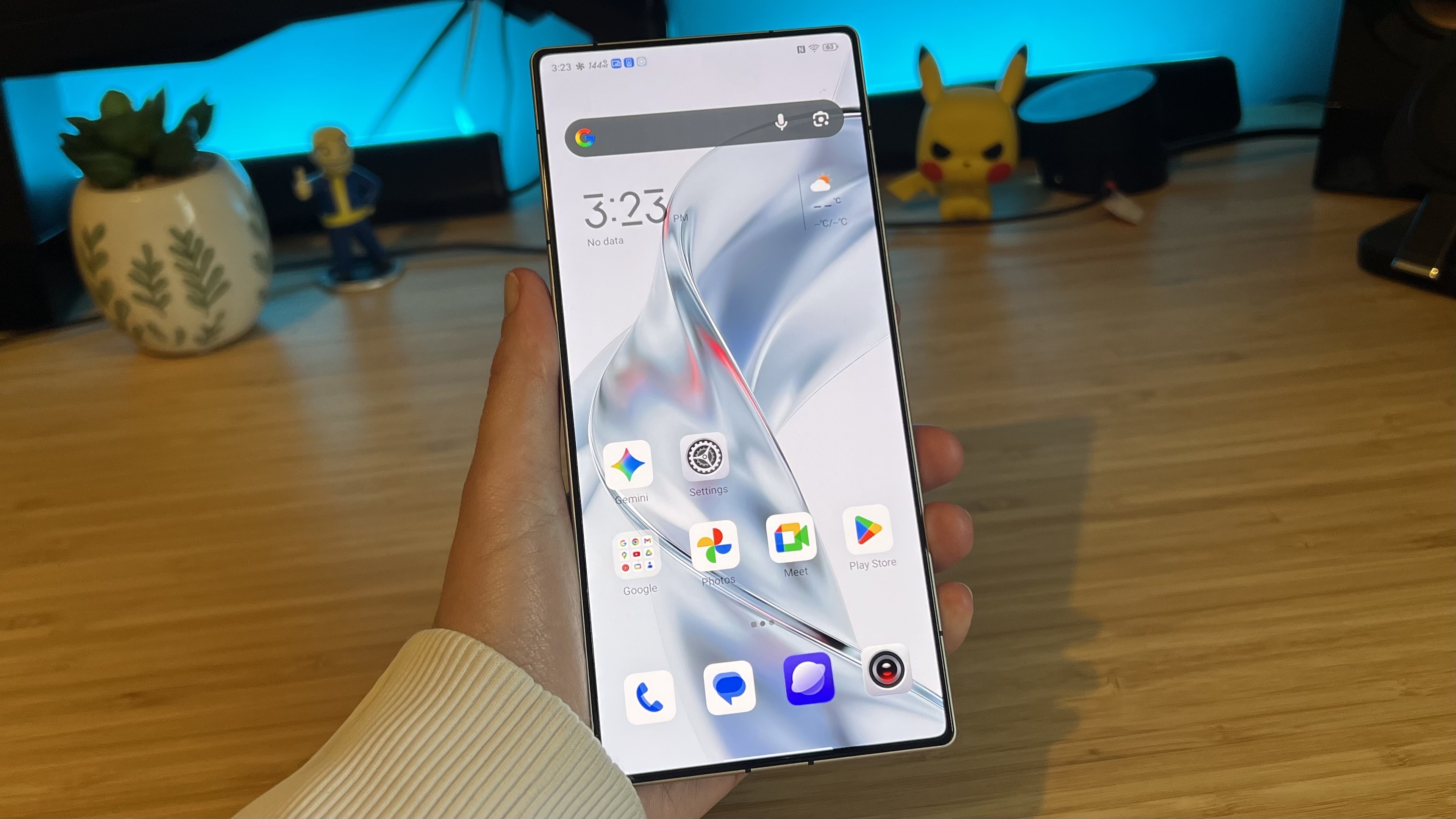 RedMagic OS running on RedMagic 11 Pro gaming phone held by reviewer in front of wooden desk