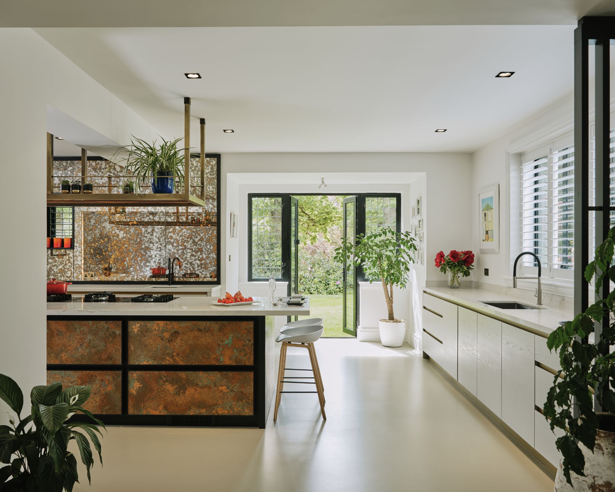 A patinaed kitchen island with aged mirror splashback
