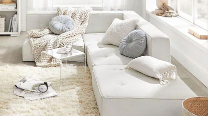 White couch with chunky knit blanket