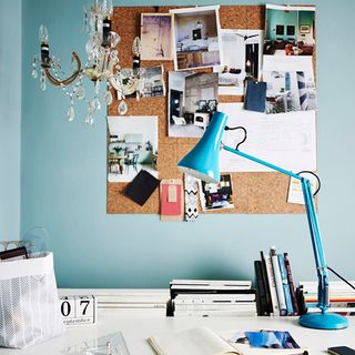 home office with desk lamp and corkboard