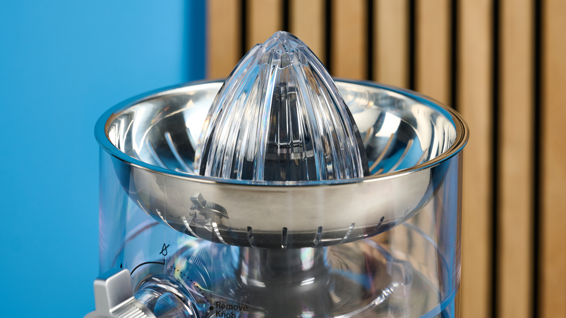 KitchenAid Go Cordless Citrus Juicer in matte black photographed in front of a blue background.