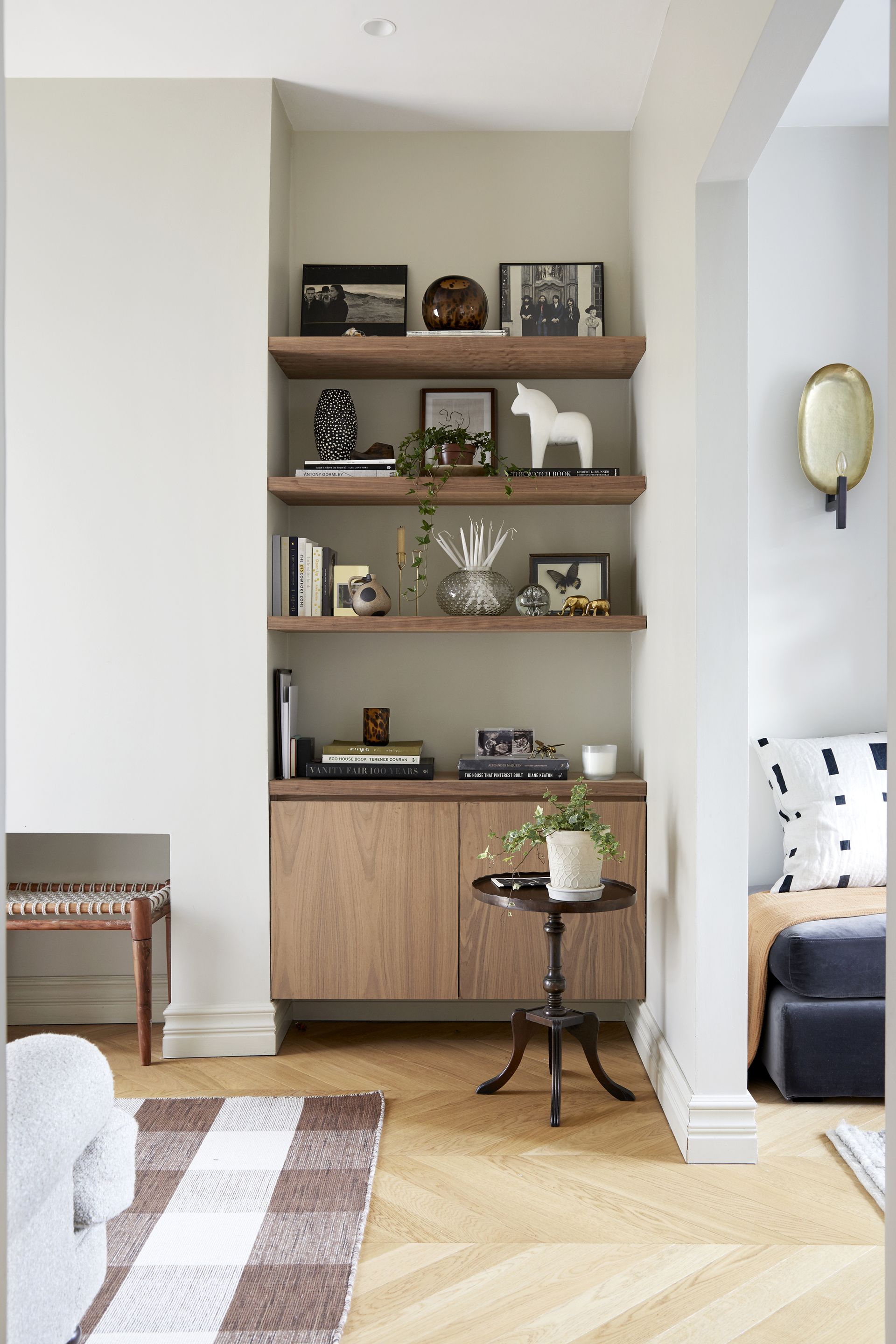 : View of grey painted alcove to the side of the chimney breast with inbuilt wooden cupboard and shelves