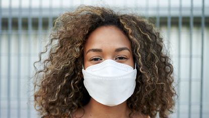 portrait of young woman with antiviral mask outdoors