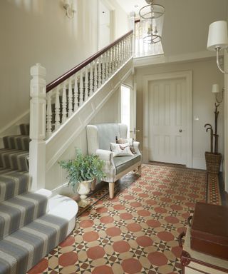 Victorian hallway tiles in brown and red in a hallway with classic entryway bench