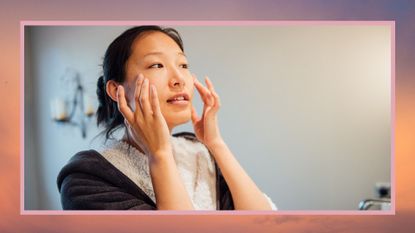 woman washing her face in her bathroom wearing a dressing gown, against a reddish background, to illustrate what does non-comedogenic mean