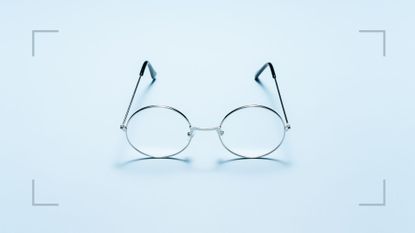 Pair of wire framed glasses sitting on a surface, representing the question of how often should you have an eye test