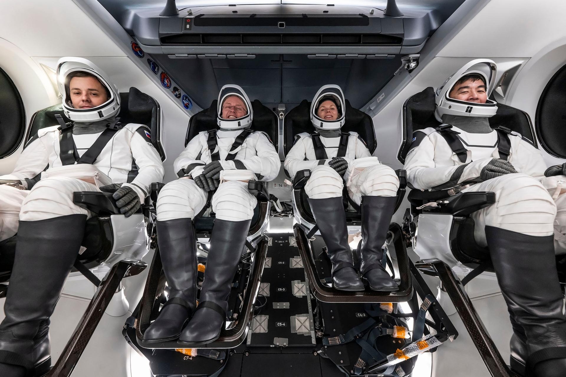 astronauts in white spacesuits pose for portraits