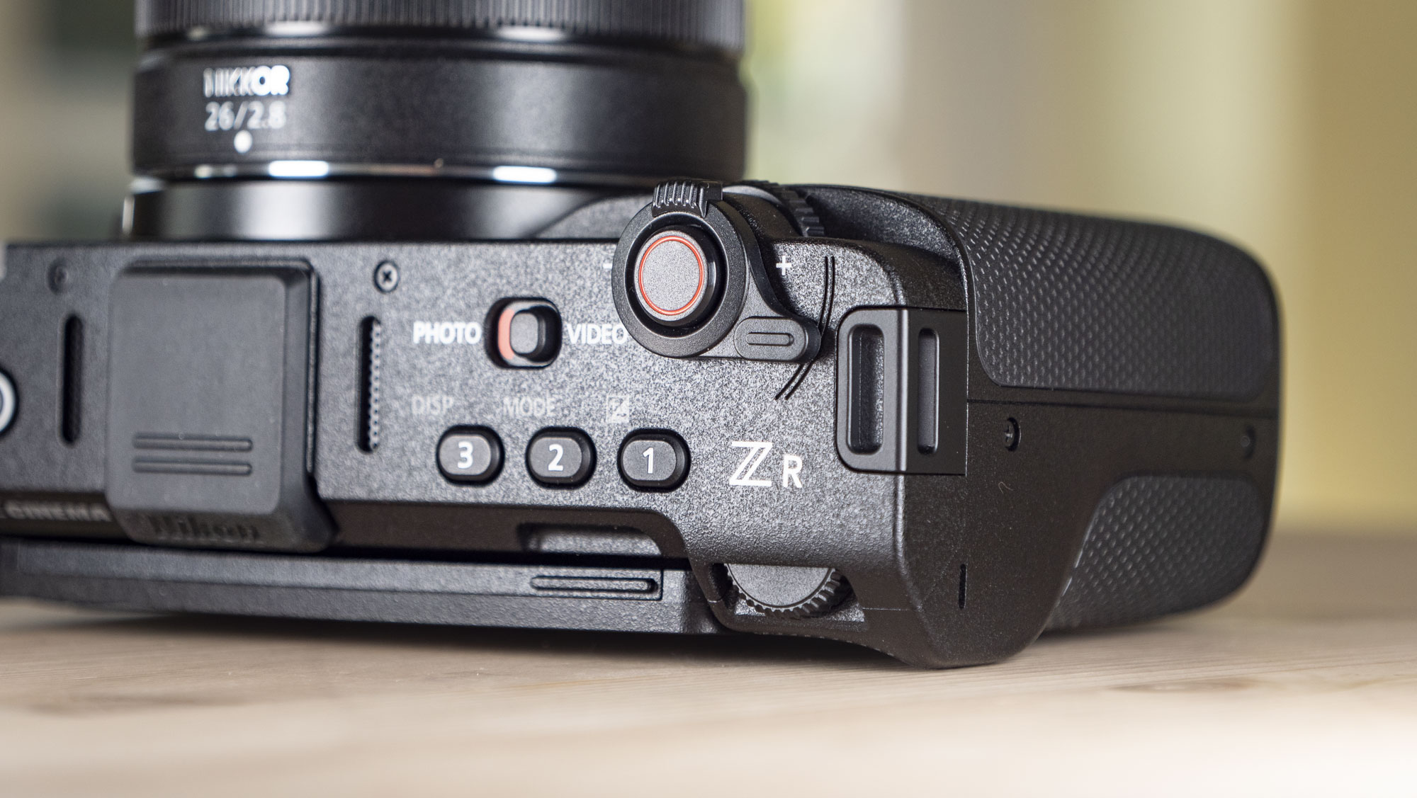 Nikon ZR product photos – camera on a wooden table, close up of top buttons