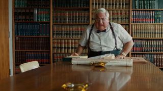 Michael Lerner standing up from a table in A Serious Man