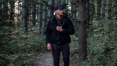 Men walking in the forest wearing the Instinct 3 Tactical Edition