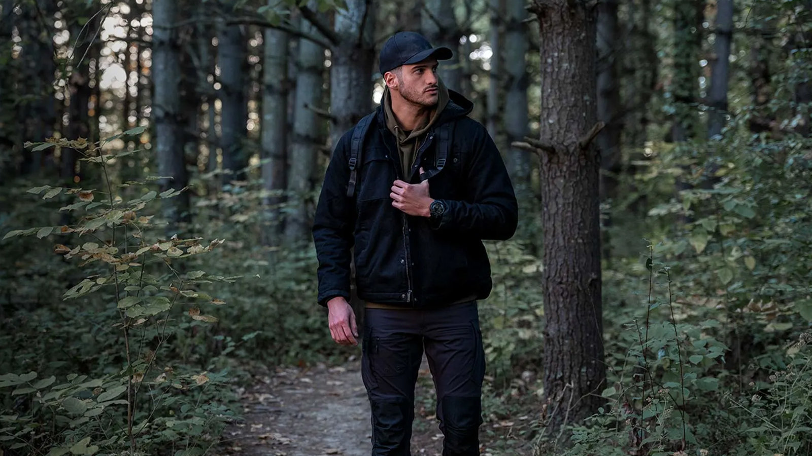 Men walking in the forest wearing the Instinct 3 Tactical Edition