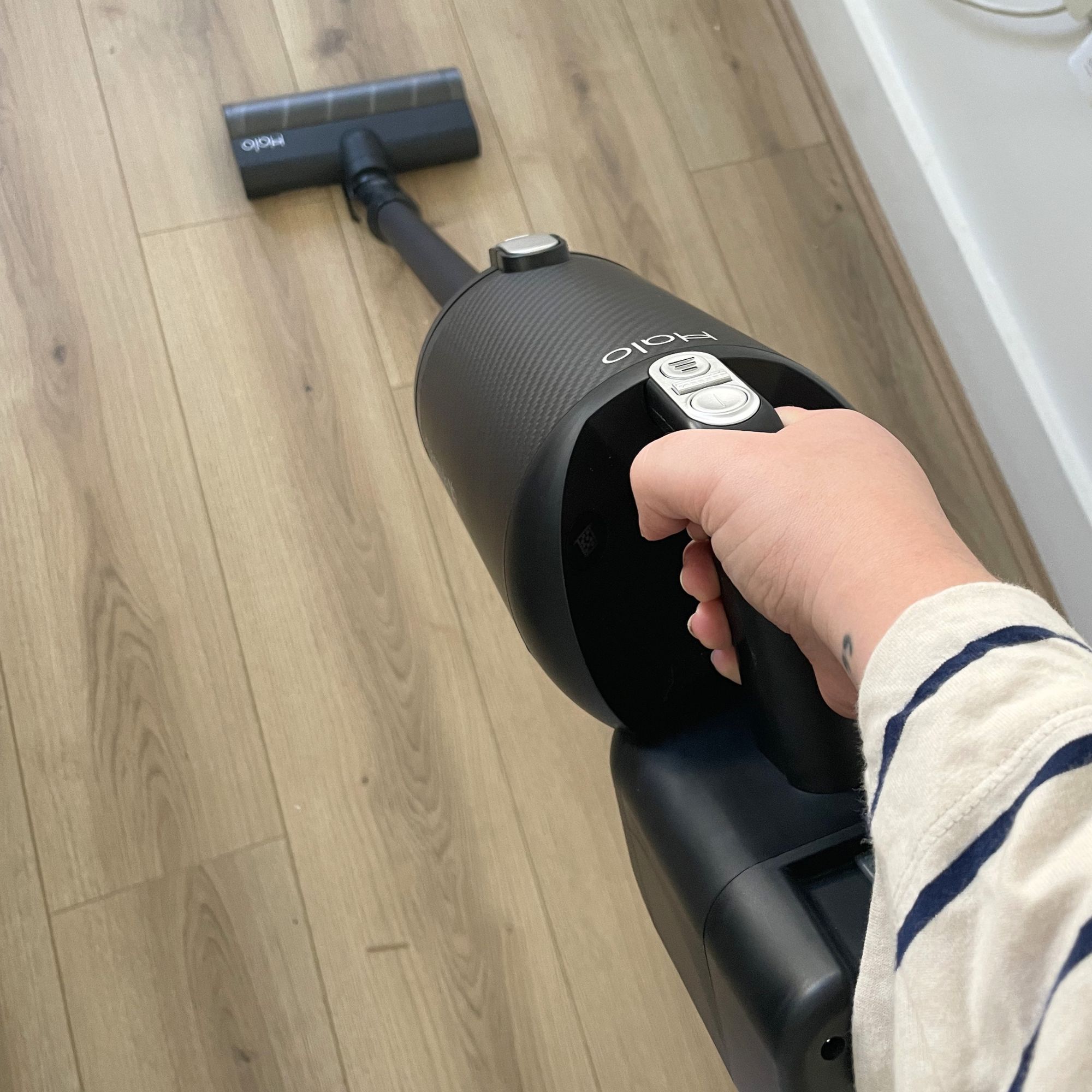 Black Halo Capsule XR Cordless Vacuum Cleaner being used to vacuum wood-effect flooring