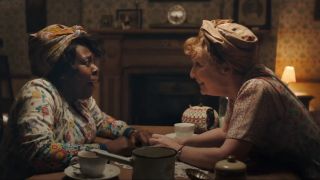 Ellen Thomas and Lesley Manville share a joyful outburst at the kitchen table in Mrs. Harris Goes to Paris.
