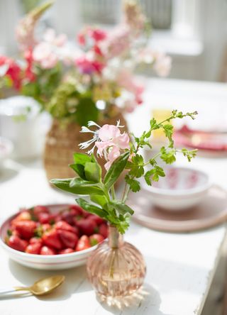 picture of sweet pea in vase on set dinner table with bigger bunch behind