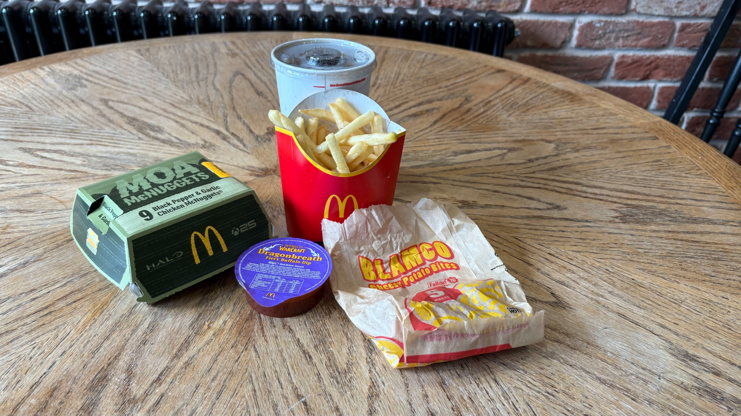 McDonald's Xbox Side Missions meal on a wooden table, featuring Halo Moa McNuggets, Fallout Blamco bites, and WoW dip.