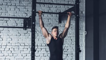 The best pull-up bars can help you a big back, as big as this person has who's performing a wide grip pull up using a wall-mounted pull up bar