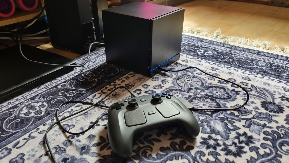 A Steam Machine in front of a TV setup, with the Steam Controller connected