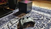 A Steam Machine in front of a TV setup, with the Steam Controller connected