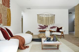 A boho style living room with a macramé wall hanging