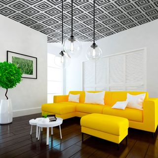 living room with white wall wooden flooring and yellow sofa