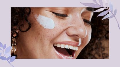 A woman smiling with a skincare smudge on her faceto illustrate the question of, 'is niacinamide good for acne' 
