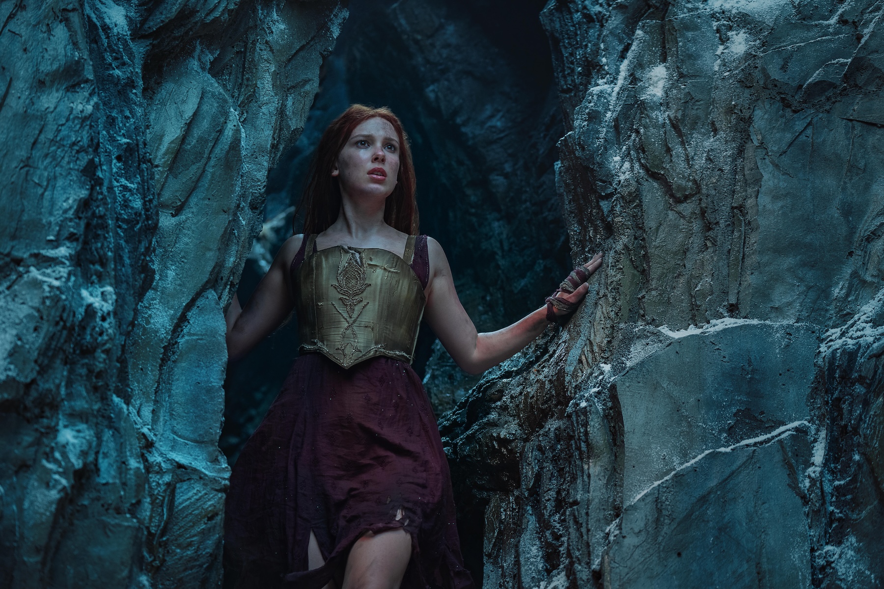 millie bobby brown stands in a cave in the netflix movie 'damsel'