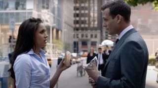 Meghan Markle holding a bagel up to Gabriel Macht in Suits 