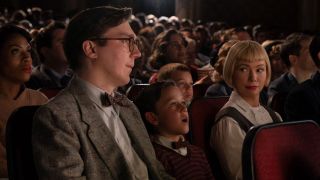 Paul Dano, Michelle Williams and Mateo Zoryna sitting in movie theater in The Fabelmans