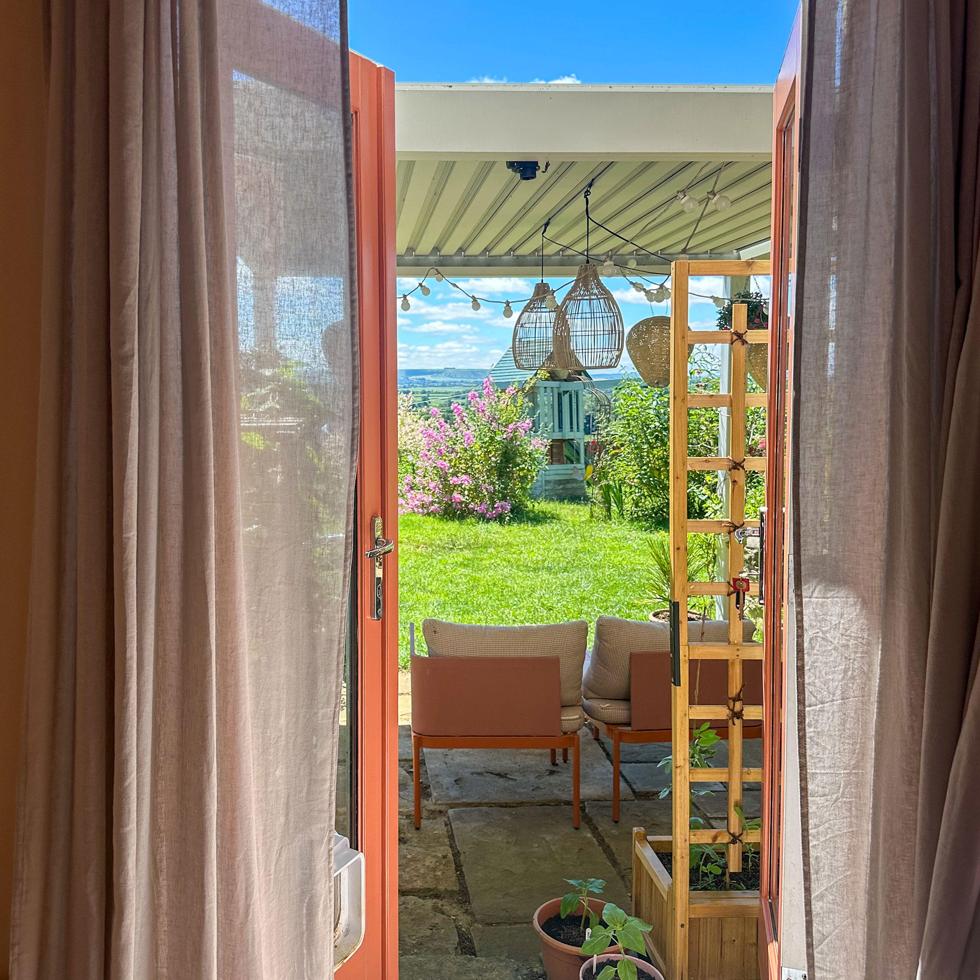 Open doors leading out onto stone patio in garden