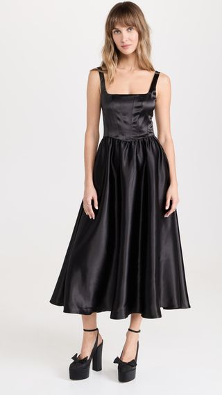 model wears black tank top bustier midi dress in a black satin material with tall black satin pumps