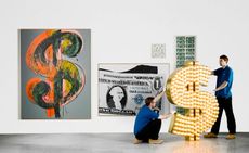Various sized US dollar themed artworks on display at Sotheby's 