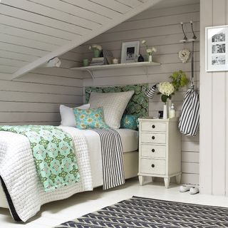 attic guest bedroom with white strip wall and bed
