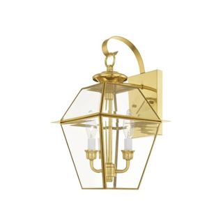 A polished gold glass diamond shaped lantern hanging from a curved hook attached to a matching base