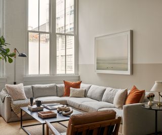 tall ceiling living room modern apartment with corner couch and orange accents