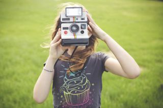 Child holding Polaroid camera
