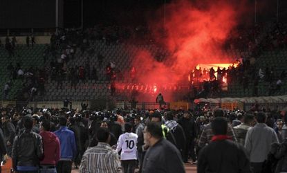 Soccer fans flee from a fire at Port Said Stadium in Cairo Thursday