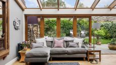 conservatory with grey sofa and potted plants