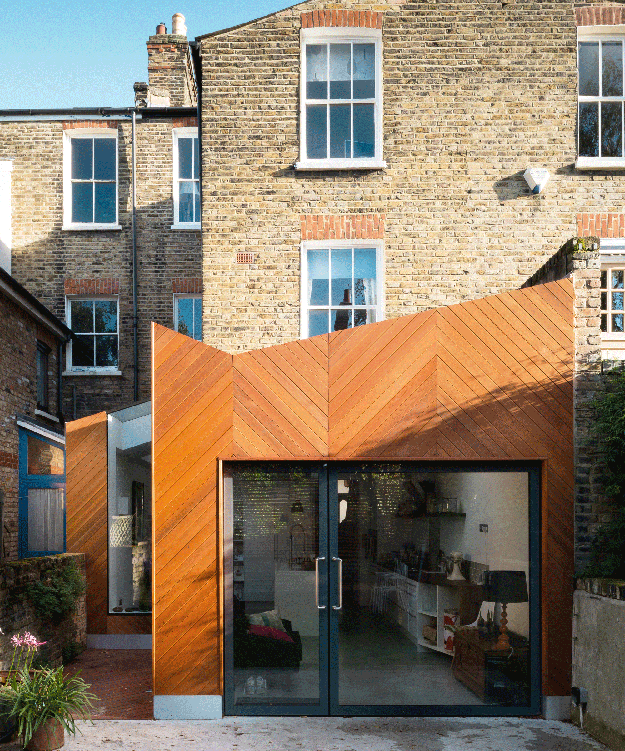 The rear exterior view of a kitchen extension clad in wood